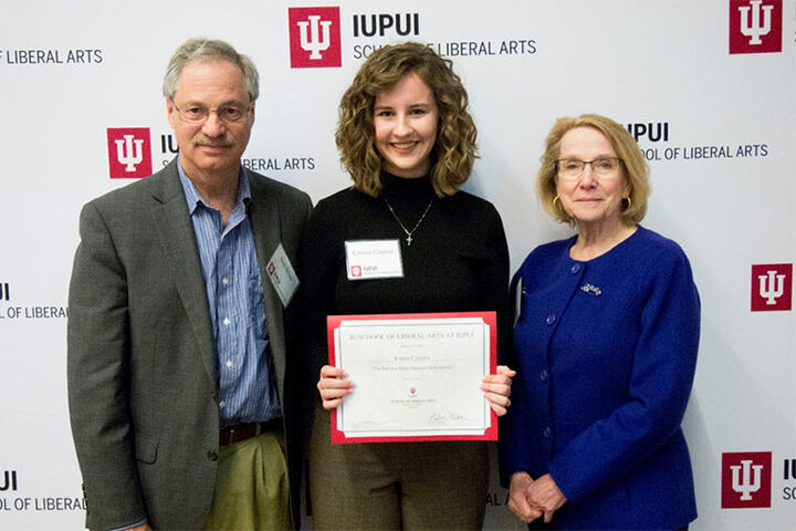 A student holds a certificate indicating she has received the Barbara White Thoreson Scholarship.